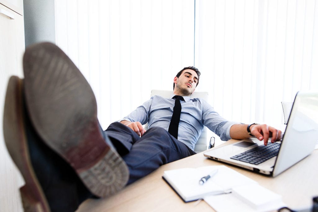 Man sitting back waiting for computer to work