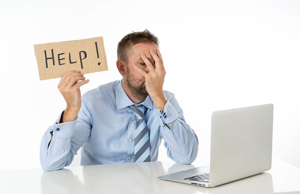 Young businessmen showing help sign desperate from understaffed IT department.